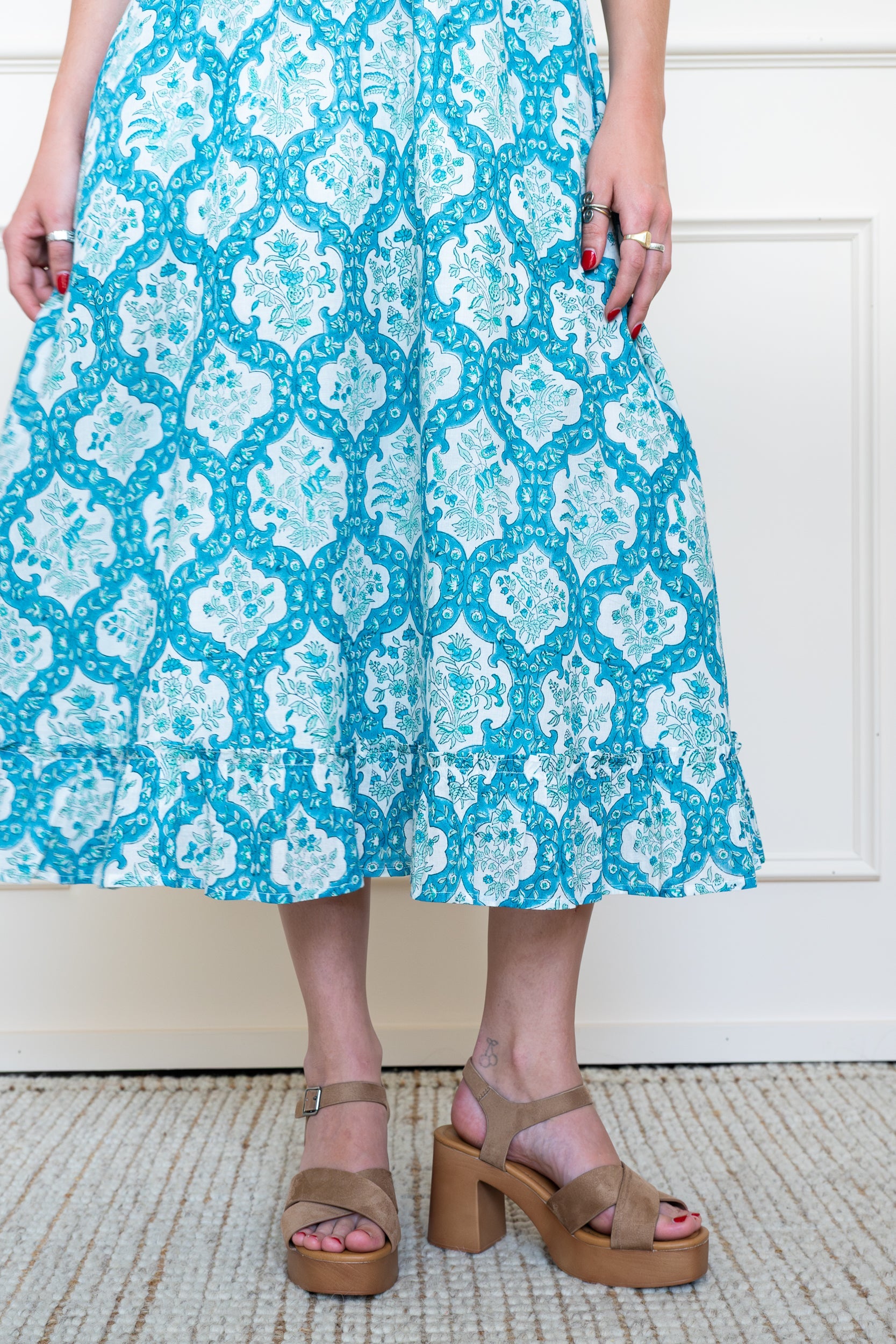 Close up of tiered skirt on Airlie Dress in Ocean Corals Blue showing midi length volume and floral hand block print.