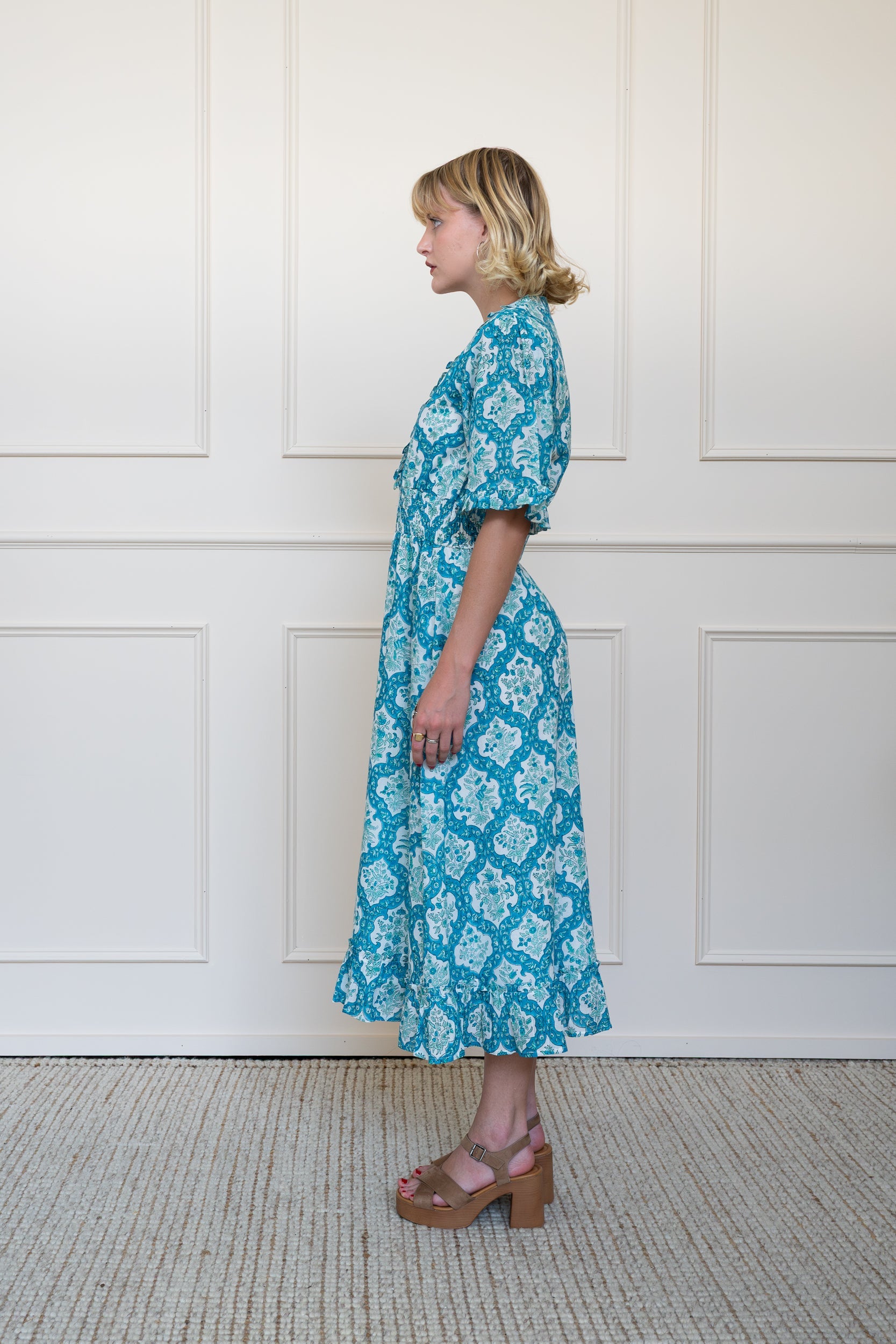 Side profile of Airlie Dress showing elbow length puff sleeves and modest midi length fit.