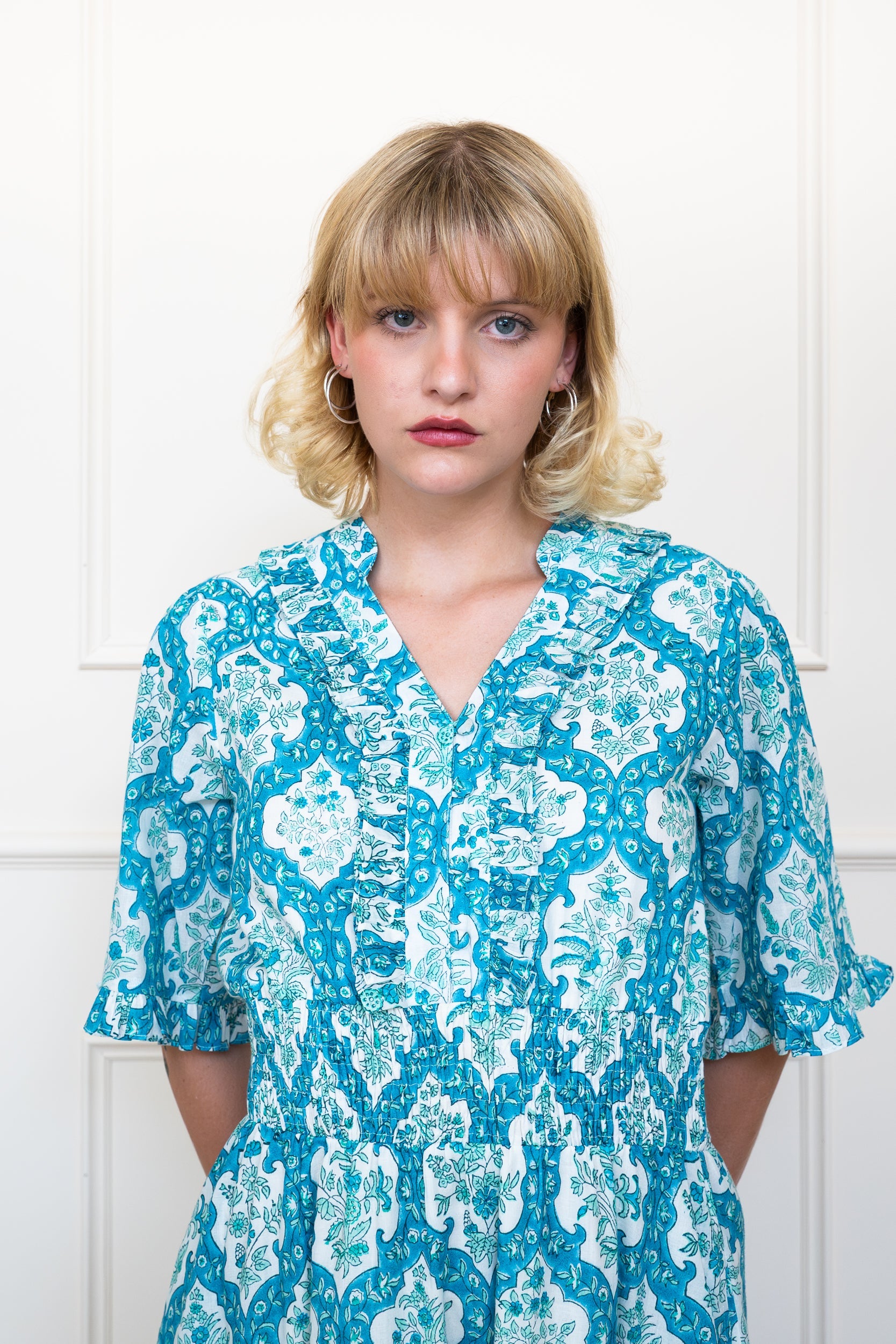 Close up front view of Airlie Dress in Ocean Corals showing tie neckline and puff sleeve detail.