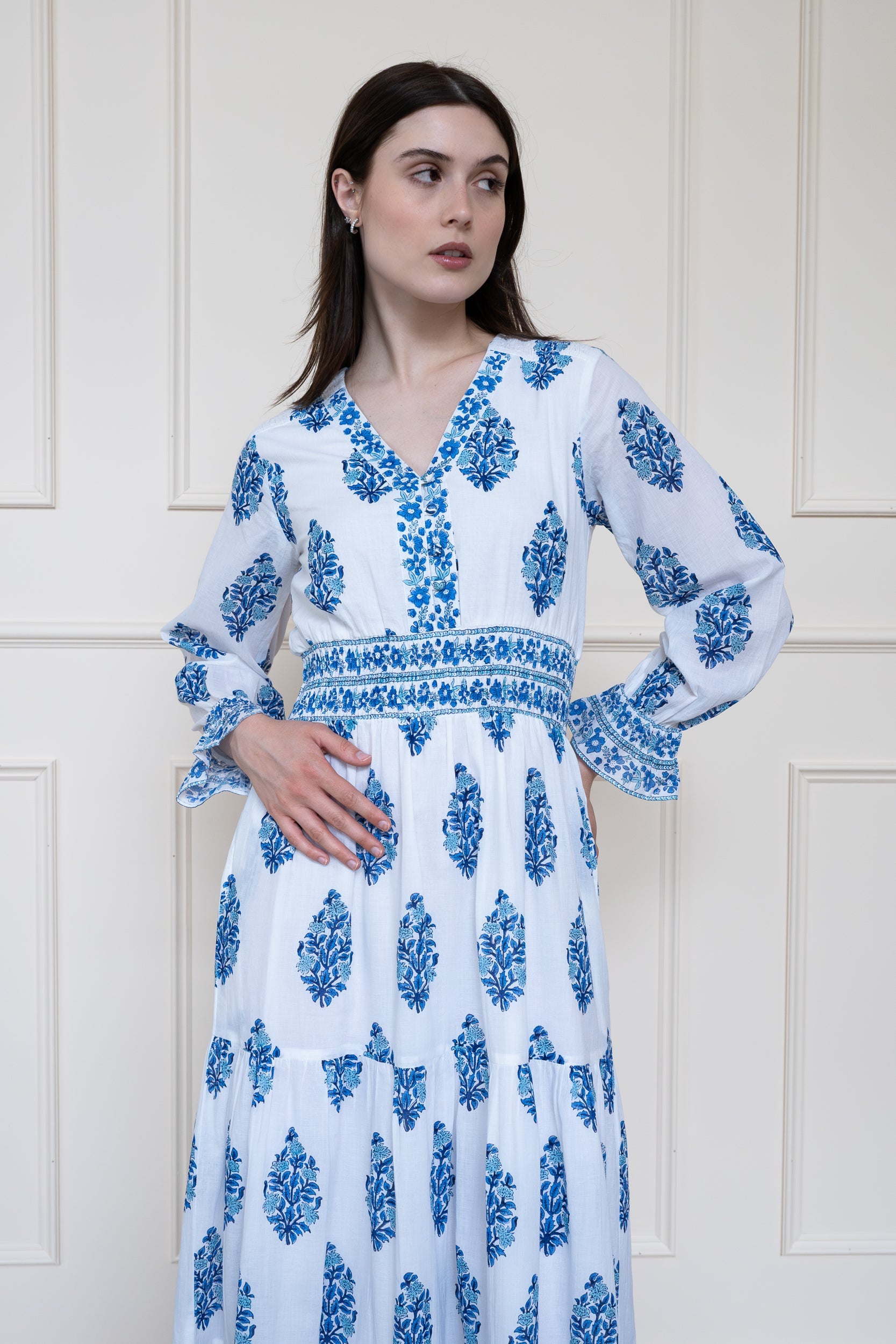 Close up front view of Mora Heritage Atherton Dress in Blue Botanicals showing smocked waist, ruffled cuffs and floral hand block print on organic cotton.
