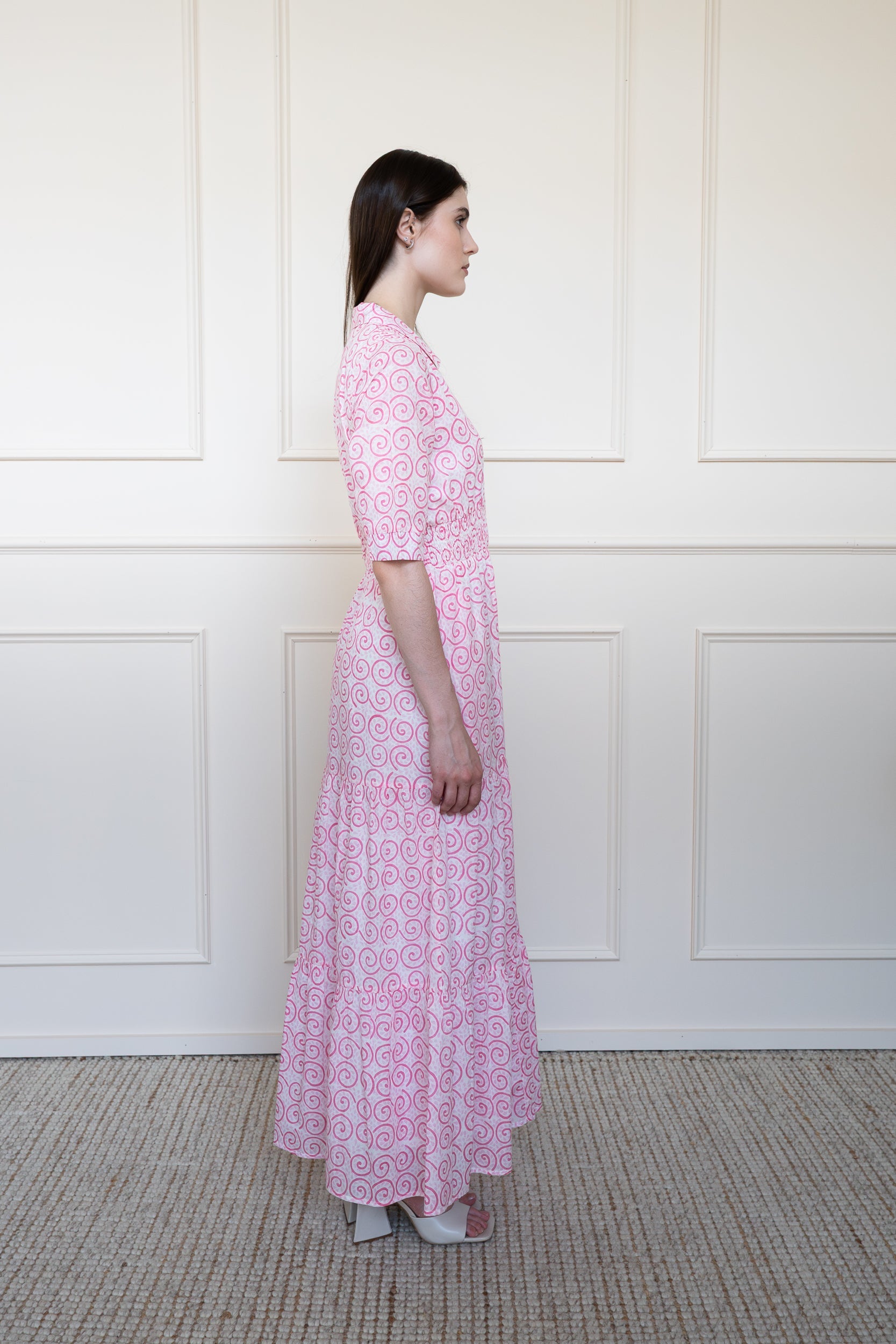 Side profile of Byron Bay Dress in pink showing elbow length sleeves and A-line silhouette.