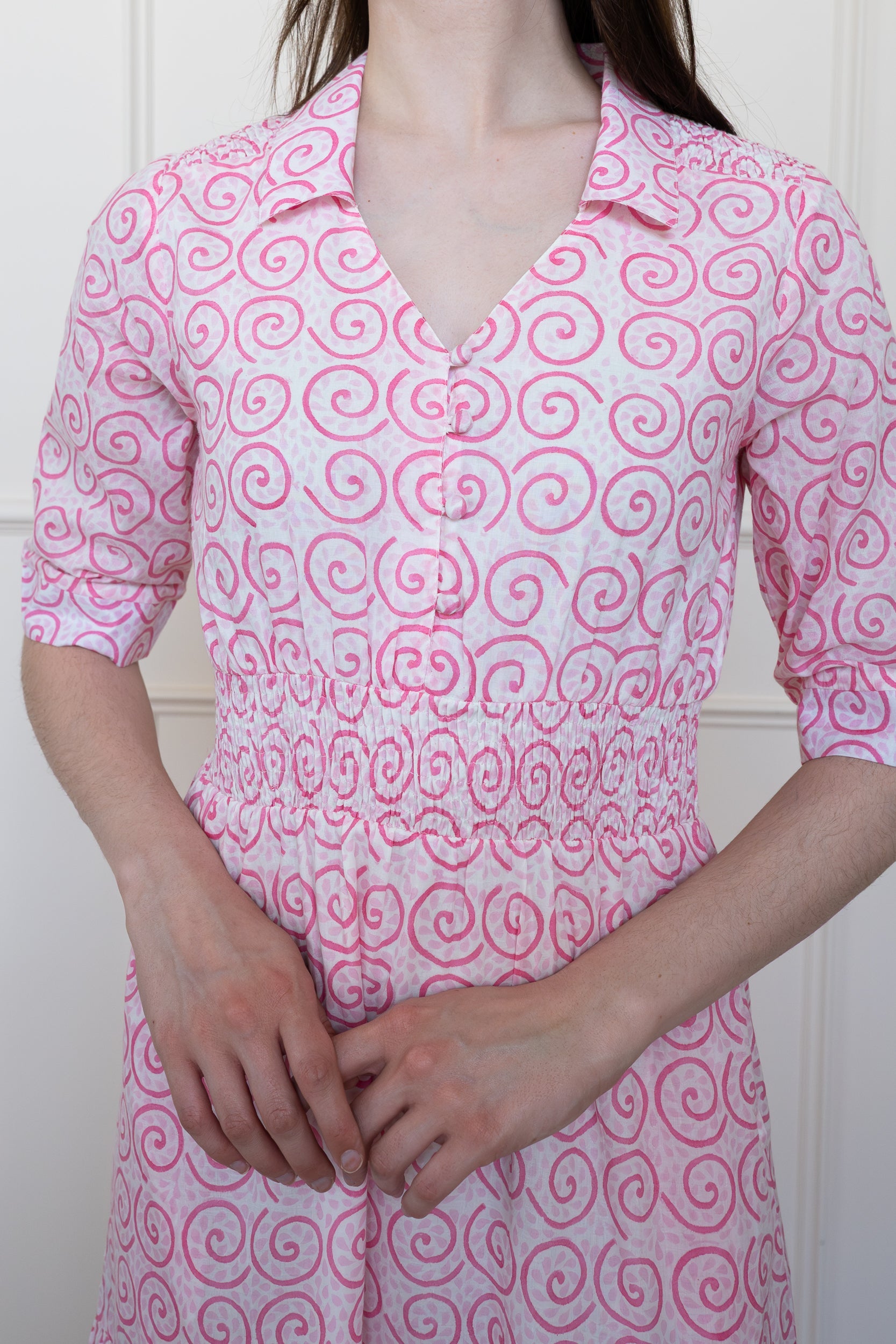 Close up front view of Byron Bay Dress in Desert Rose pink. Showing shirt collar, button details, smocked waist and floral hand block print on organic cotton.