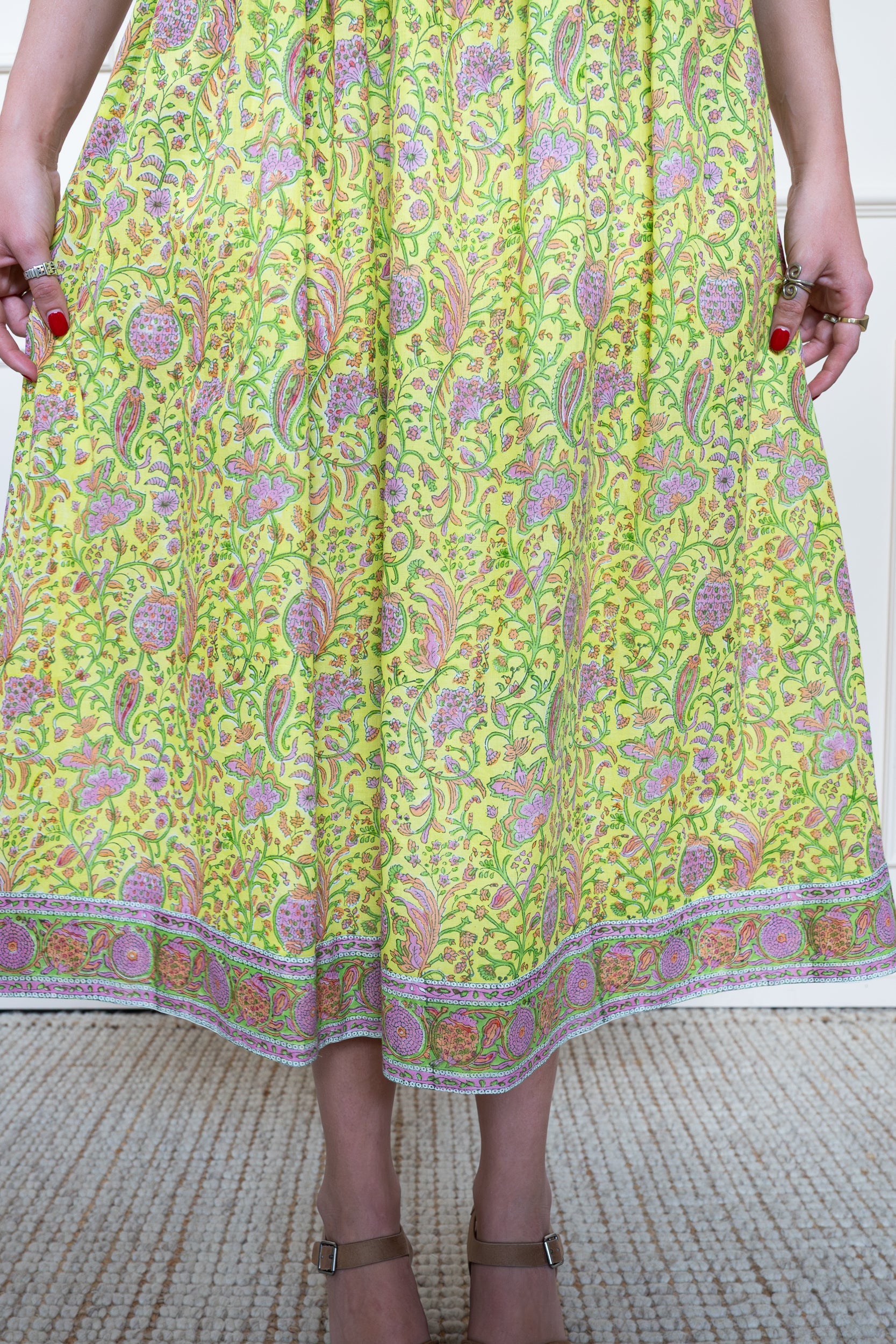 Close up of tiered skirt on Cairns Dress in Lemon Myrtle showing floral hand block print pattern and midi length volume.