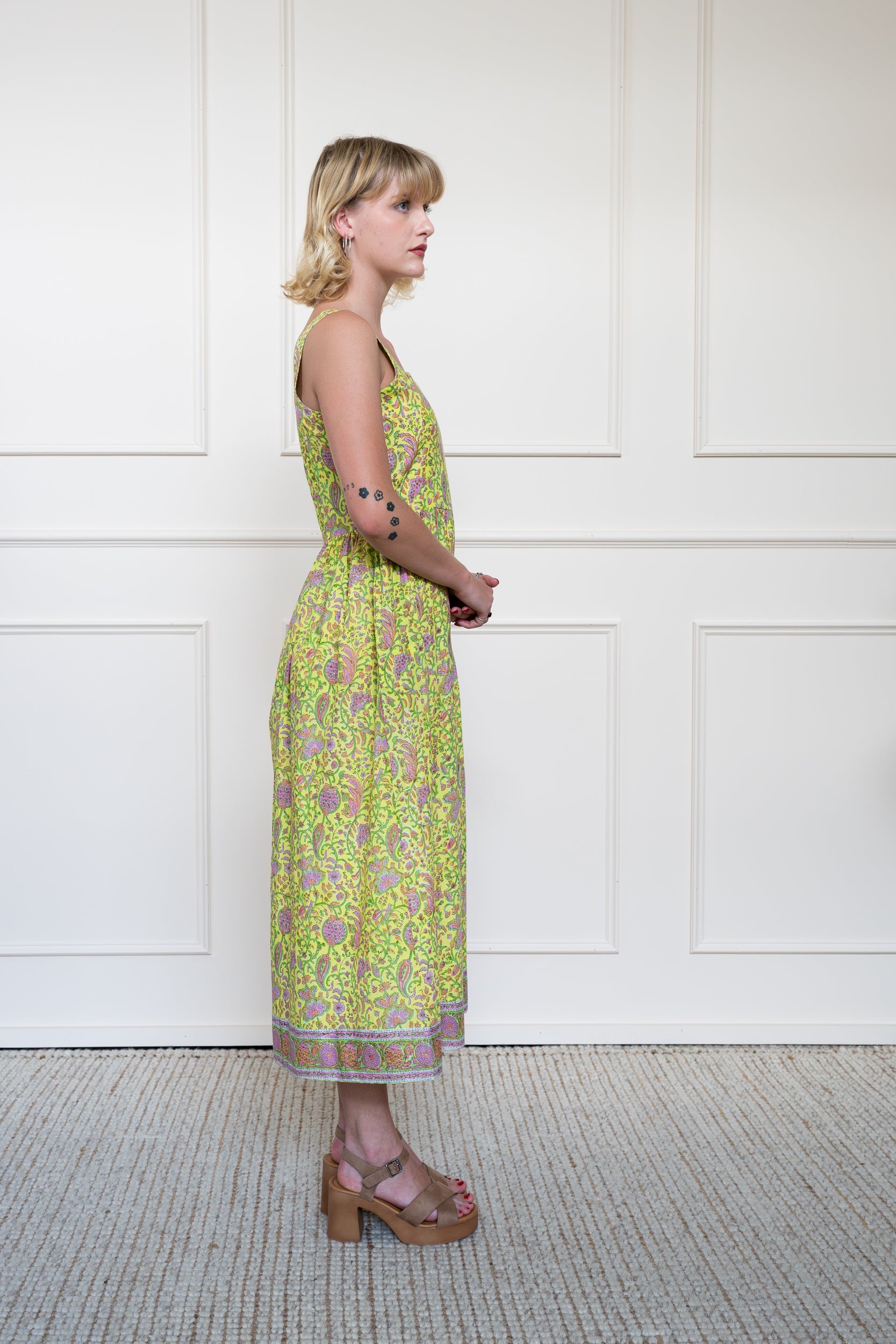 Side profile of Cairns Dress showing elbow length sleeves and modest midi length fit in yellow.