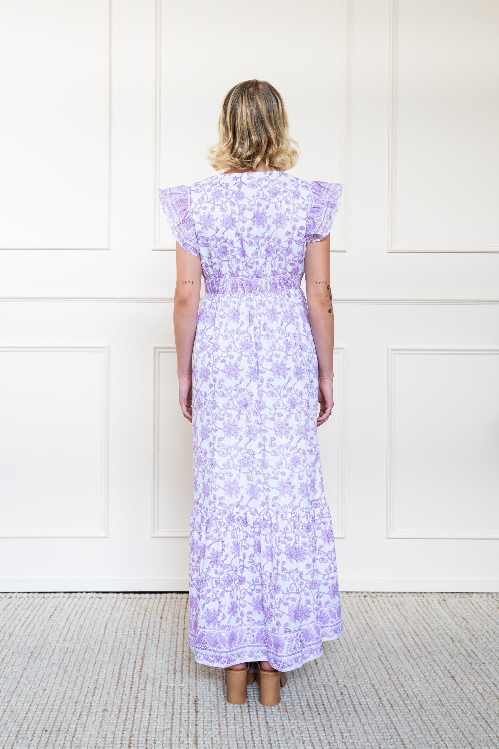 Back view of Daintree Dress in Orchid Bloom showing flattering A-line silhouette, back smocking waist, and breathable organic cotton.
