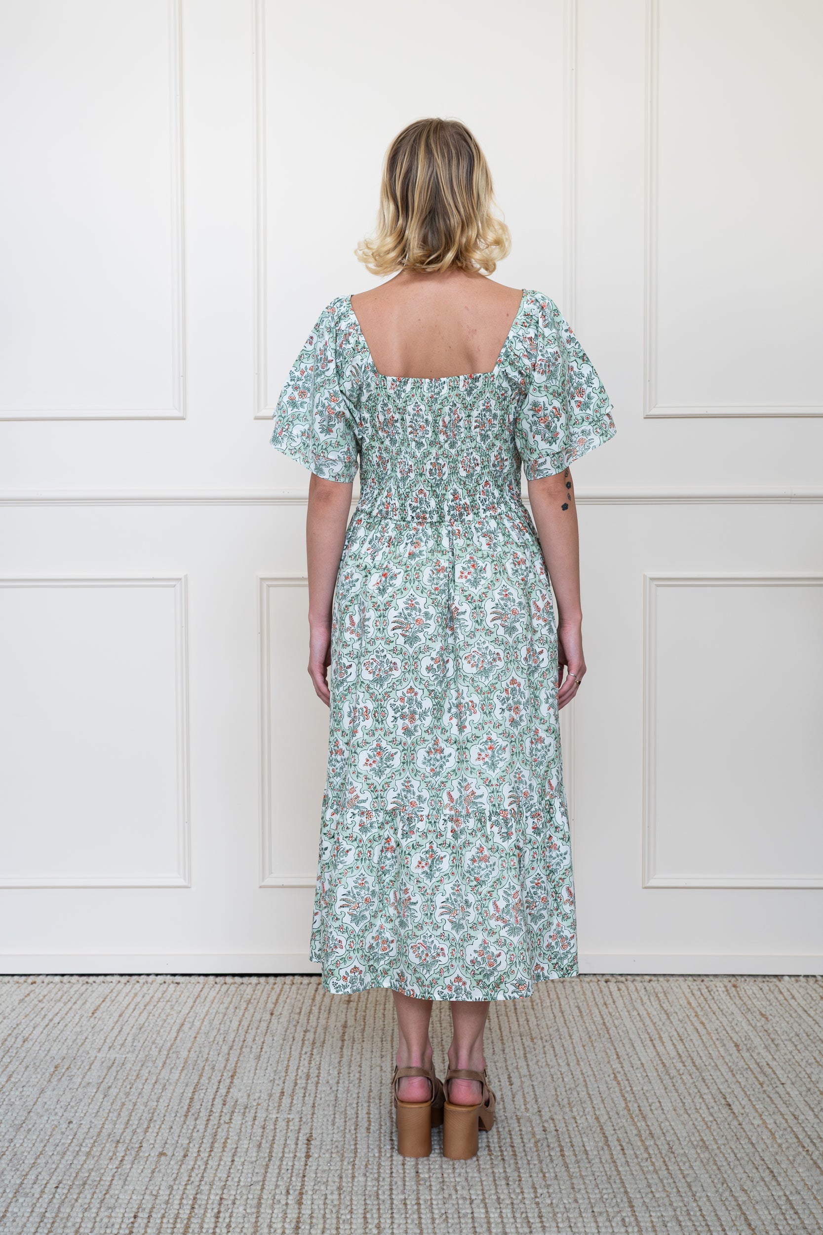 Back view of Grampians Dress in Sage Green showing flattering A-line silhouette, back smocking panel for perfect fit, and breathable organic cotton fabric.
