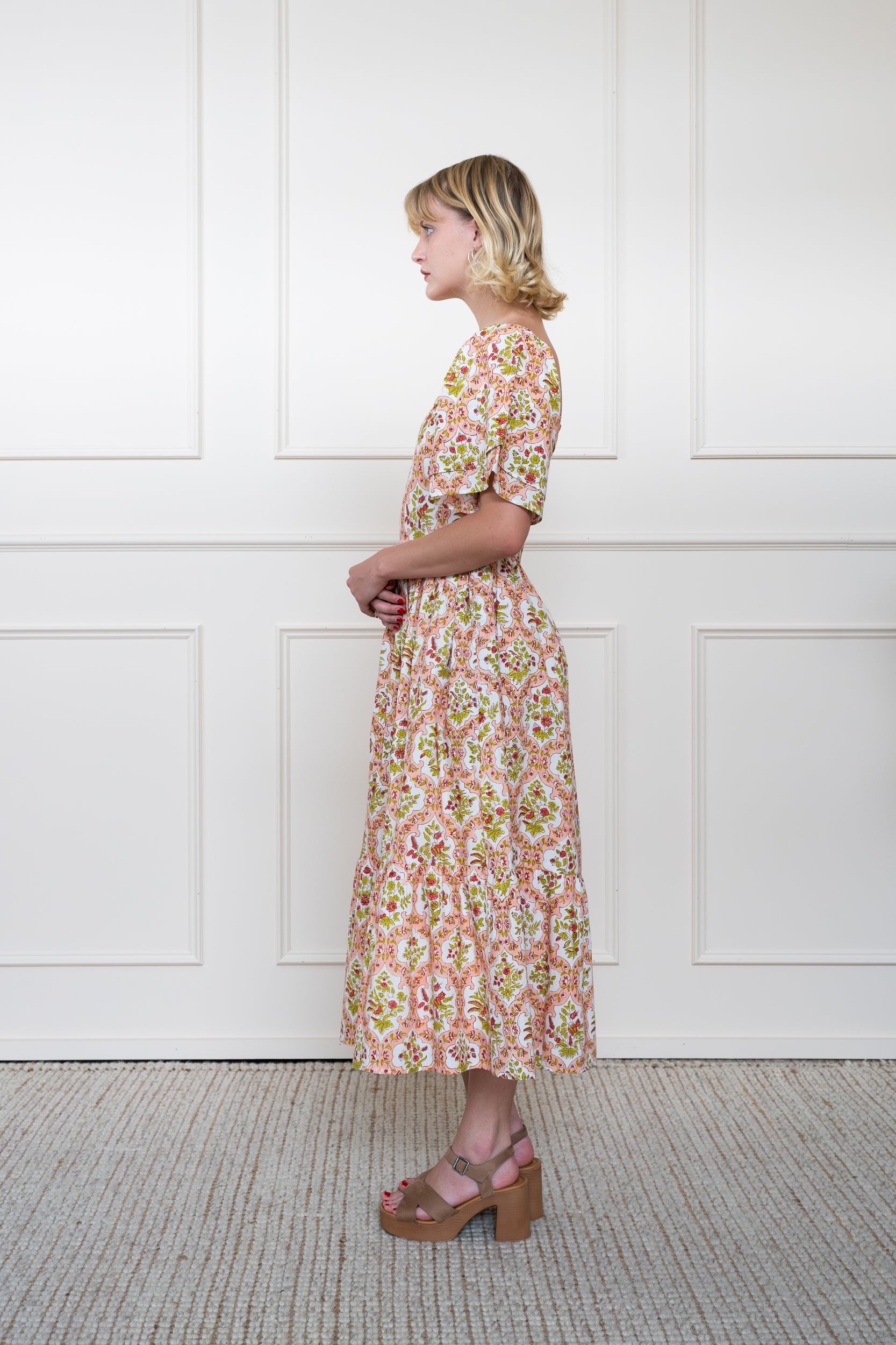 Profile view of Grampians Dress in Orange showing floral hand block print pattern and A-line skirt shape.