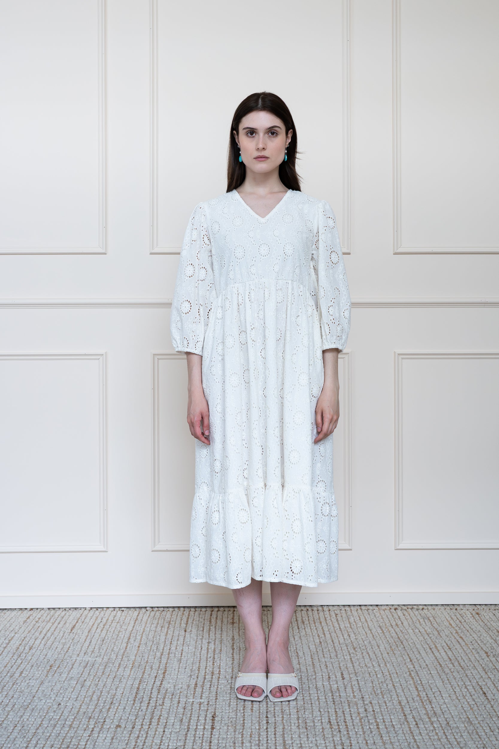 Full length front view of Tamarind Dress in white embroidery showing relaxed fit midi length and V-neckline.