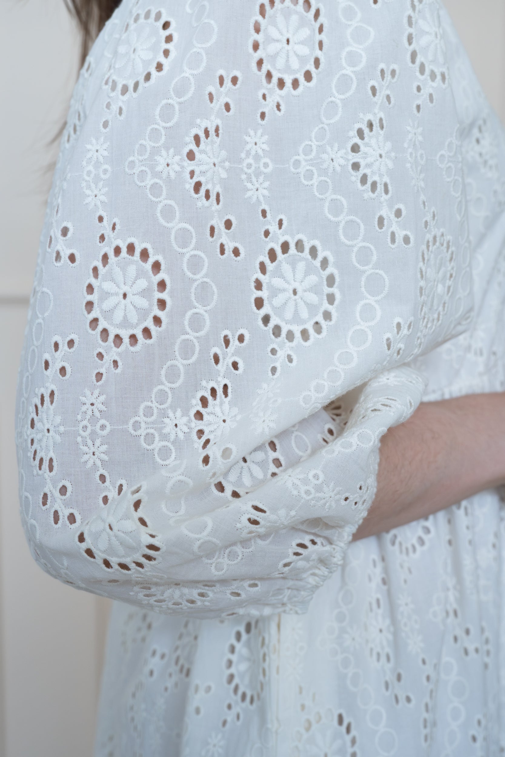Close up of Tamarind Dress in White showing relaxed fit 3/4 length sleeves and intricate schiffli embroidery.