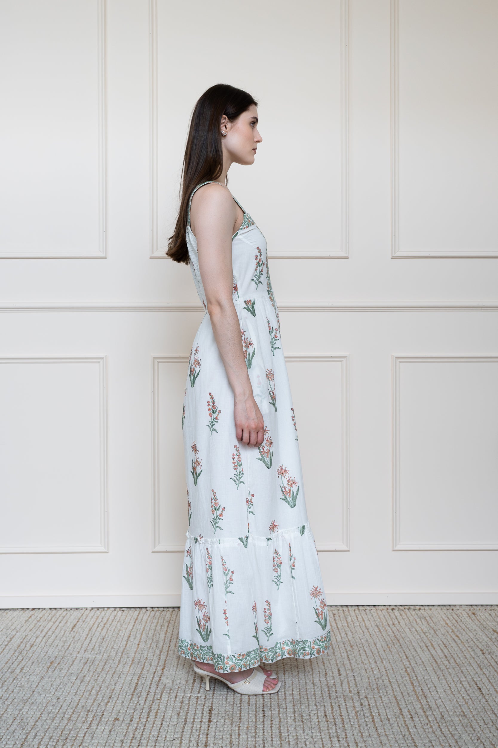 Side profile of Whitsunday Dress showing sleeveless design and modest maxi length fit in white.